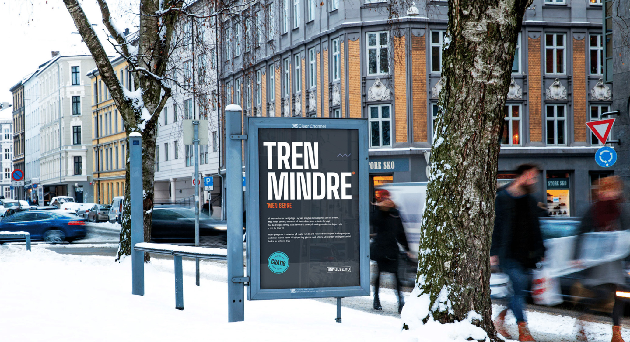 Reklameplakat for Impulse treningssenter med teksten 'Tren mindre, men bedre', plassert i en vinterkledd bygate med folk som går forbi.